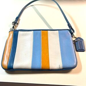 Coach leather wristlet blue,beige, striped design. 6”x 4”x 13” strap.